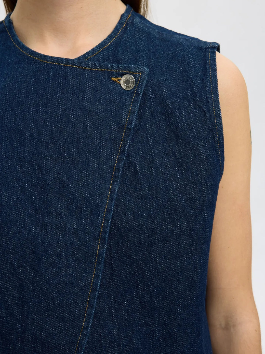 Top smanicato in denim con chiusura asimmetrica